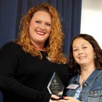 Two women holding a Celebrating Women Award